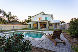 Modern home exterior with pool at dusk