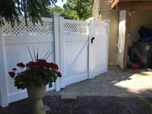 Tall white vinyl fence hiding backyard