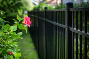 sleek black aluminum fence running alongside green garden