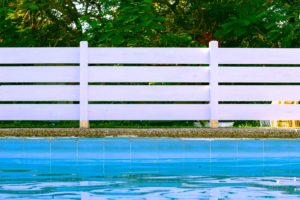 Beautiful white fence at edge of blue pool